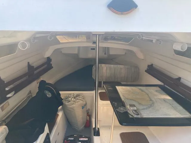 Slide: The Image of Interior of a 1997 MacGregor 26 X sailboat with navigation map and storage. - 13