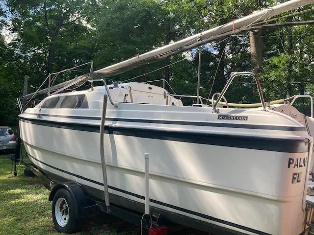 Slide: The Image of 1997 MacGregor 26 X sailboat on trailer, surrounded by trees. - 15