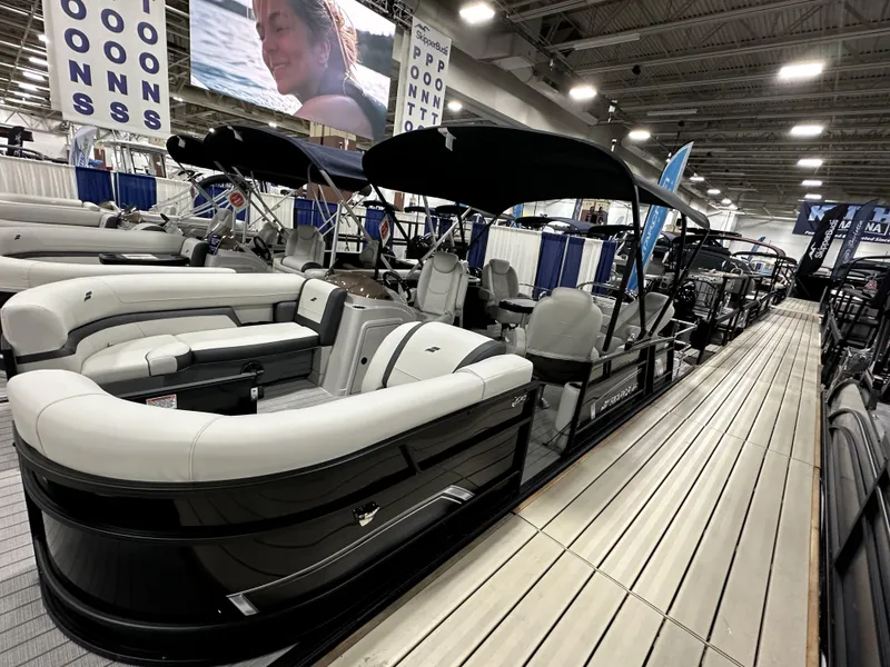 Slide: The Image of 2024 Starcraft EXS 3 HB4TT pontoon boat displayed at an indoor boat show. - 3