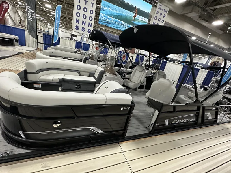 Slide: The Image of 2024 Starcraft EXS 3 HB4TT pontoon boat with sleek seating at a boat show. - 4