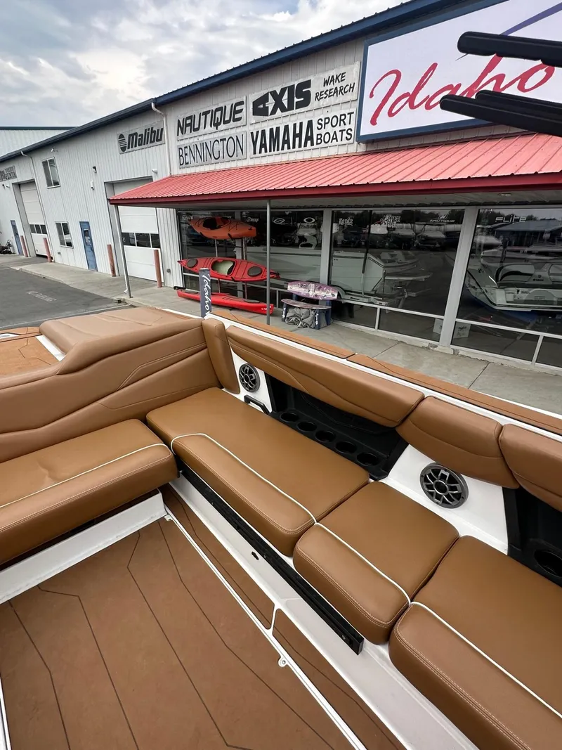 Slide: The Image of 2023 Axis T250 boat with brown seating, displayed outside a dealership. - 13