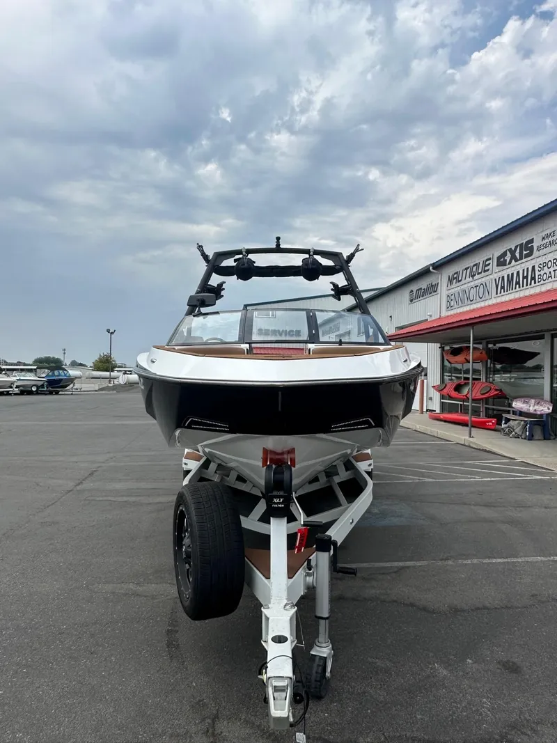 Slide: The Image of 2023 Axis T250 boat on trailer at dealership under cloudy sky. - 4