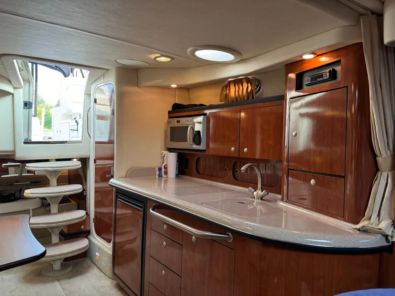 Slide: The Image of Interior of 2007 Sea Ray 340 Sundancer yacht with modern kitchen and wooden cabinetry. - 18
