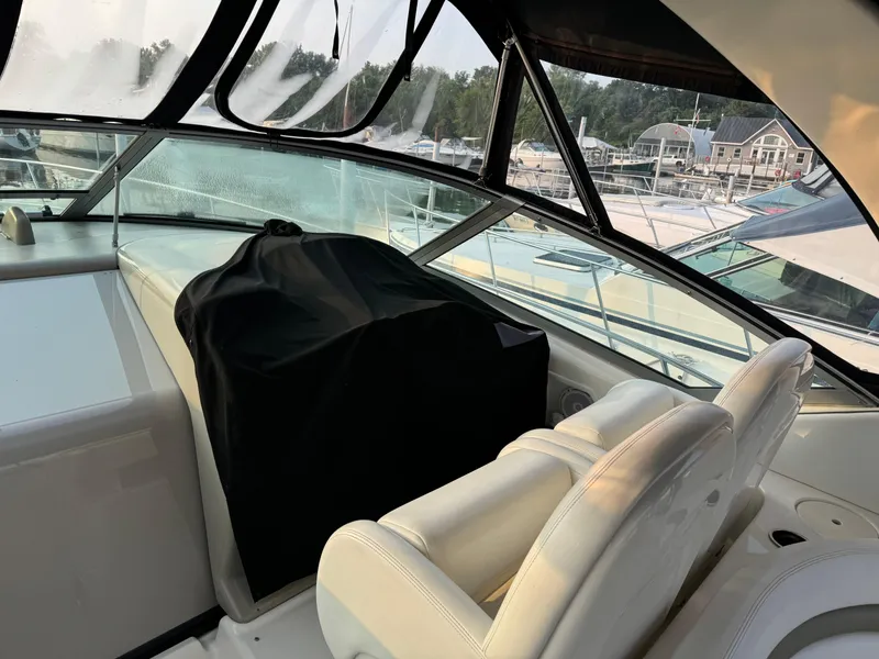 Slide: The Image of 2007 Sea Ray 340 Sundancer cockpit with covered dashboard and white seating. - 7