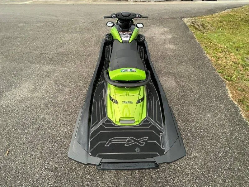 Slide: The Image of 2024 Yamaha Waverunner FX Cruiser SVHO, green and black, with audio system, parked on pavement. - 15