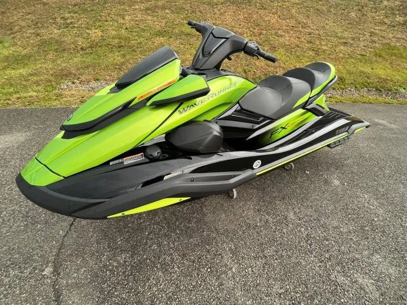 Slide: The Image of 2024 Yamaha Waverunner FX Cruiser SVHO, lime green, parked on pavement. - 3