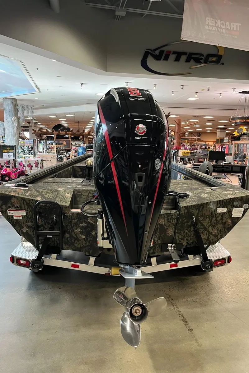 Slide: The Image of 2024 Ranger RB210 boat with camo design and powerful outboard motor in showroom. - 5