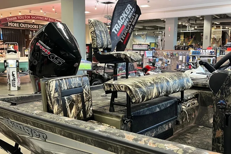 Slide: The Image of 2024 Ranger RB210 boat with camo seats and powerful engine in showroom. - 8