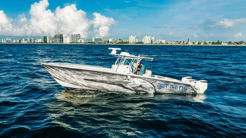 Slide: The Image of 2018 SeaHunter 39 Tournament boat cruising on ocean near city skyline. - 0
