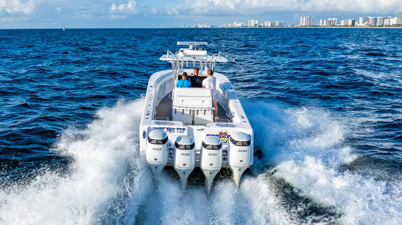 Slide: The Image of 2018 SeaHunter 39 Tournament boat cruising on open ocean near city skyline. - 10