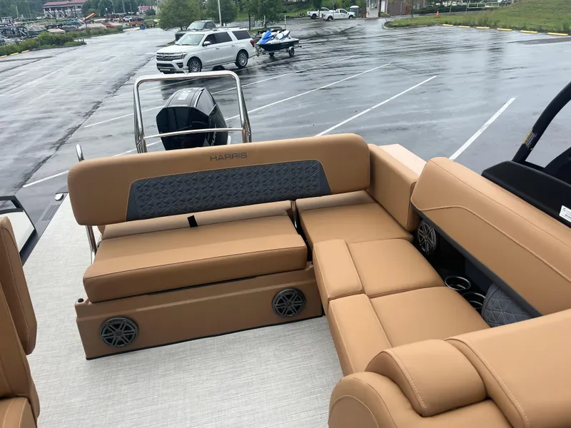 Slide: The Image of 2025 Harris Solstice 230 boat interior with tan seating in a parking lot. - 5