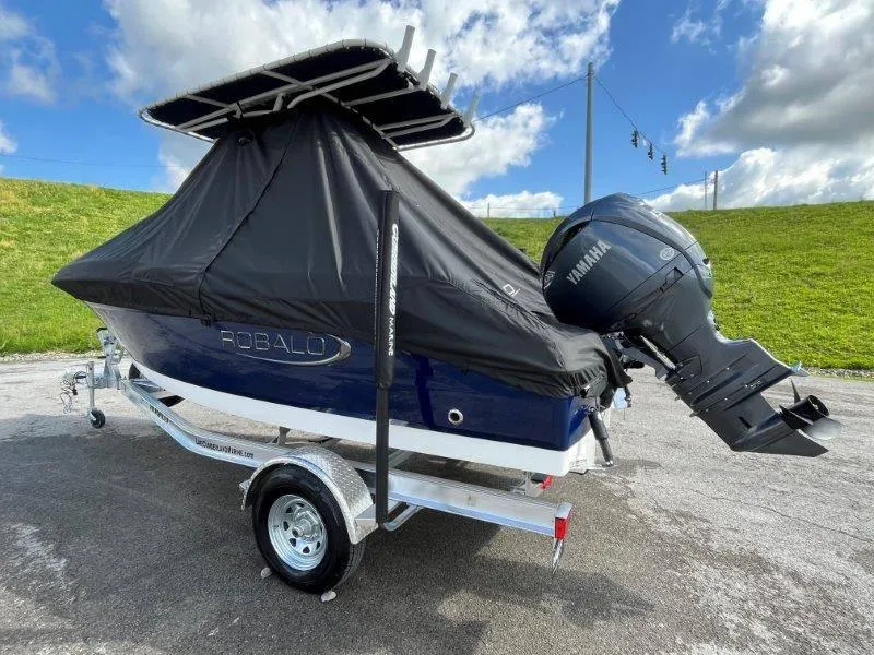 Slide: The Image of 2024 Robalo R180 boat with Yamaha engine, covered and on a trailer, under a blue sky. - 10