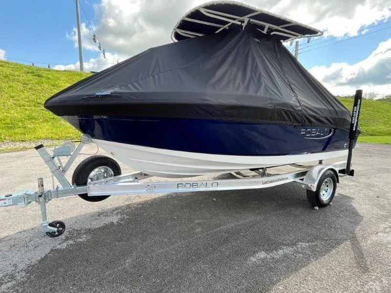 Slide: The Image of 2024 Robalo R180 boat on trailer with protective cover, parked outdoors. - 11