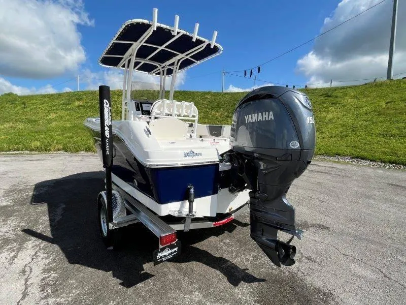 Slide: The Image of 2024 Robalo R180 boat with Yamaha 150 engine on a trailer, parked outdoors. - 23