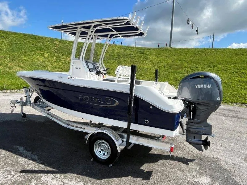 Slide: The Image of 2024 Robalo R180 boat with Yamaha engine on trailer, parked outdoors. - 26