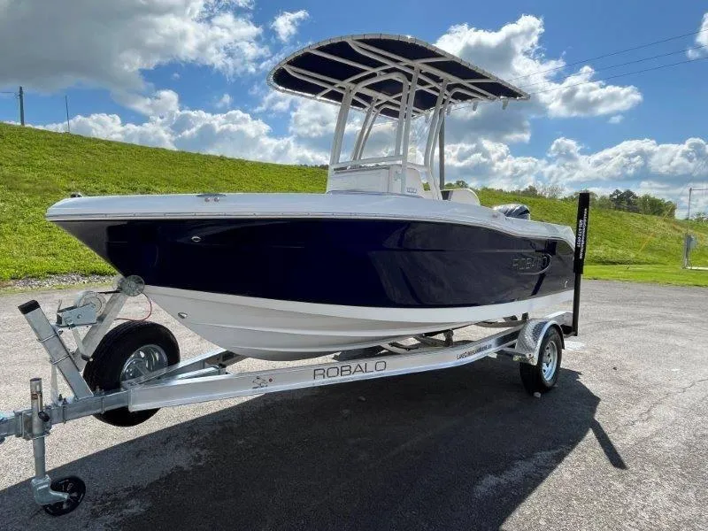 Slide: The Image of 2024 Robalo R180 boat on trailer under blue sky. - 29