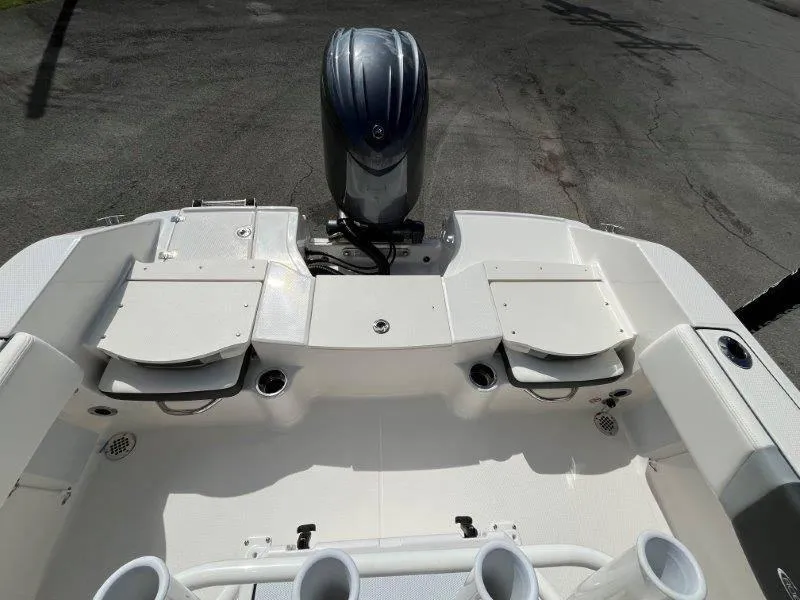 Slide: The Image of 2024 Robalo R180 boat interior with engine, featuring storage compartments and cup holders. - 33
