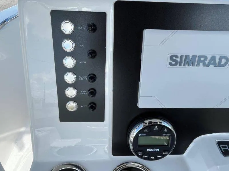 Slide: The Image of 2024 Robalo R180 boat dashboard with Simrad display and Clarion audio controls. - 35