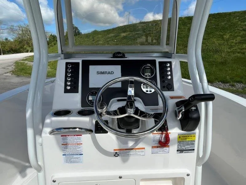 Slide: The Image of 2024 Robalo R180 boat dashboard with Simrad display and steering wheel. - 39