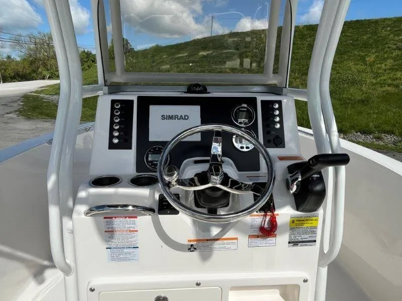 Slide: The Image of 2024 Robalo R180 boat dashboard with Simrad display and steering wheel. - 40