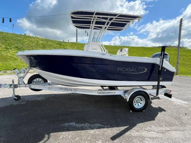 Slide: The Image of 2024 Robalo R180 boat on trailer under blue sky. - 41