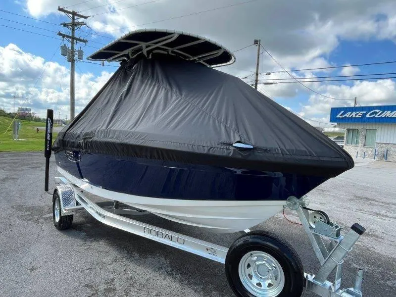 Slide: The Image of 2024 Robalo R180 boat with cover on trailer, parked outdoors. - 6