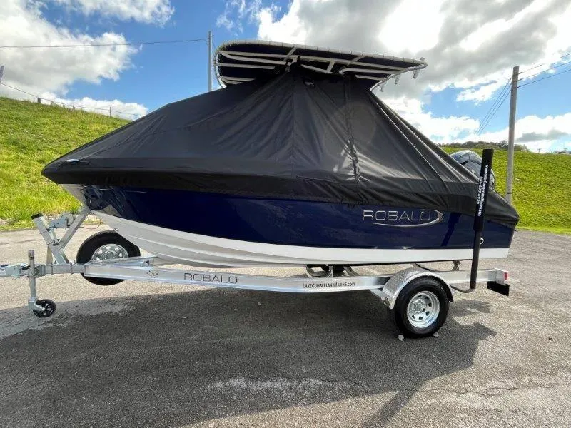 Slide: The Image of 2024 Robalo R180 boat on trailer with protective cover, parked outdoors. - 8