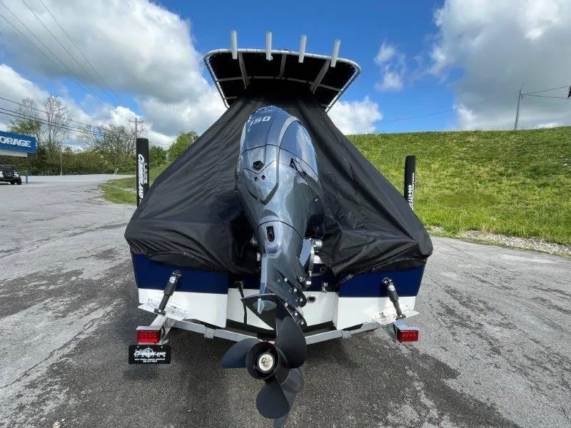 Slide: The Image of 2024 Robalo R180 boat with Yamaha outboard motor, covered and parked on a road. - 9