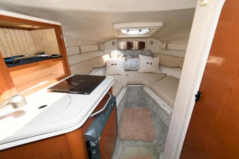 Slide: The Image of 2008 Sea Ray 240 Sundancer cabin interior with cozy seating and kitchenette. - 10