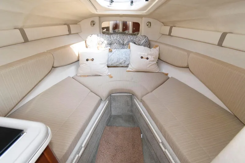 Slide: The Image of 2008 Sea Ray 240 Sundancer cabin interior with beige seating and decorative pillows. - 11