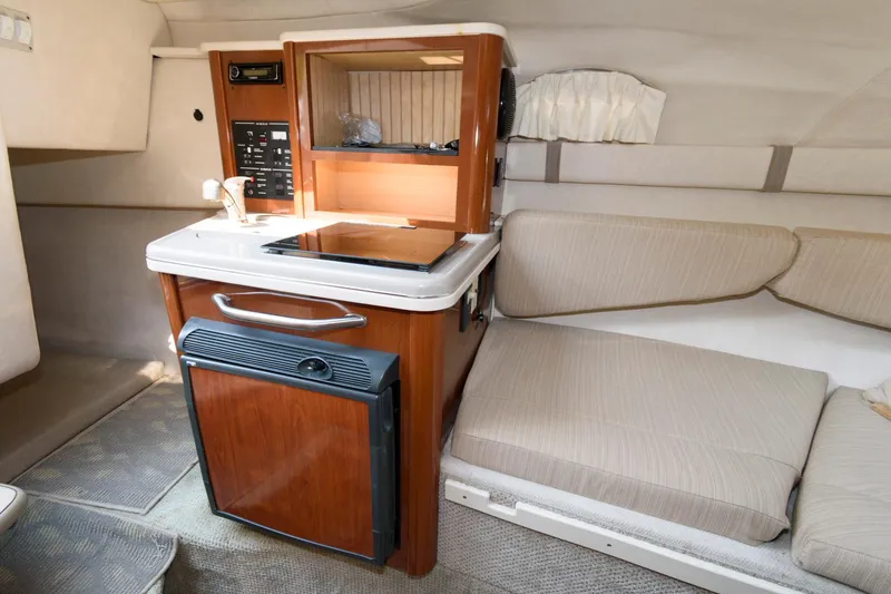 Slide: The Image of 2008 Sea Ray 240 Sundancer cabin interior with kitchenette and seating area. - 12