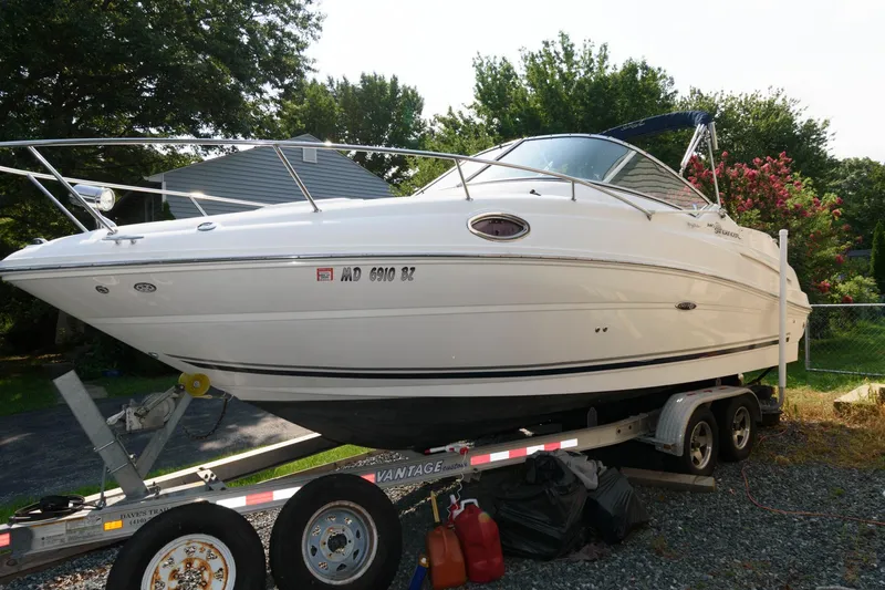 Slide: The Image of 2008 Sea Ray 240 Sundancer boat on trailer, parked outdoors. - 2