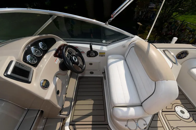 Slide: The Image of 2008 Sea Ray 240 Sundancer boat interior with steering wheel and white seating. - 5