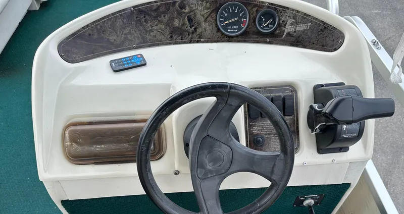 Slide: The Image of Console of a 2001 Sea Hunt 20 boat with steering wheel and controls. - 13