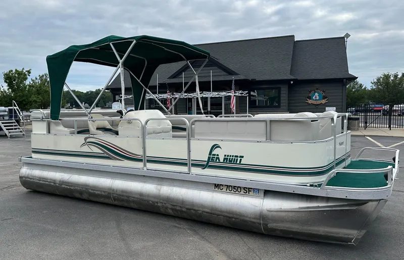 Slide: The Image of 2001 Sea Hunt 20 pontoon boat with green canopy, parked on pavement. - 3