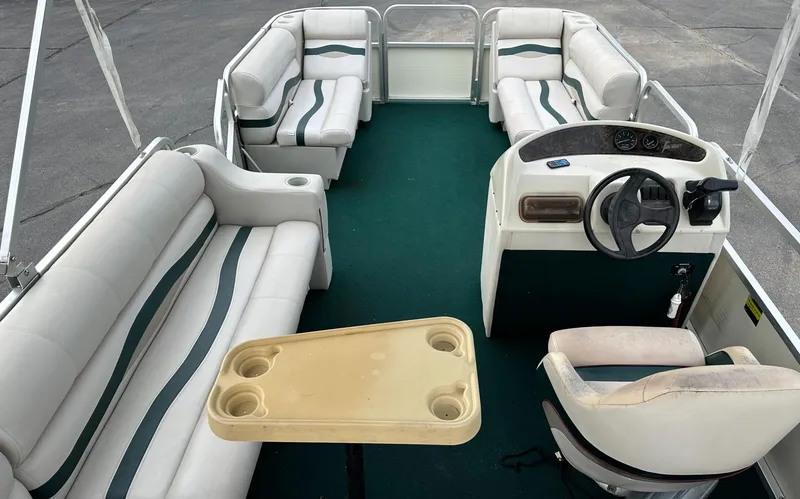 Slide: The Image of Interior of a 2001 Sea Hunt 20 boat with green carpet and white seating. - 7