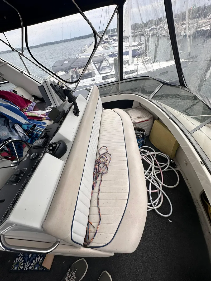 Slide: The Image of 1993 Carver 33 Aft Cabin interior with seating and marina view. - 11