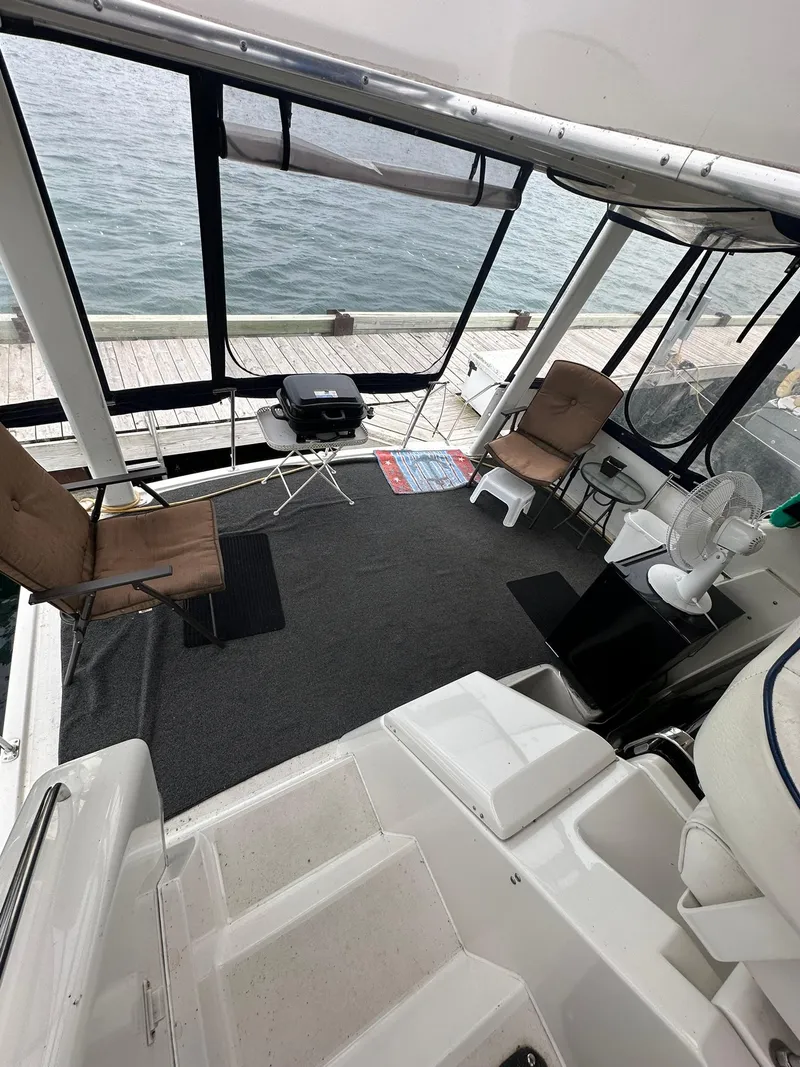 Slide: The Image of 1993 Carver 33 Aft Cabin interior with seating, table, and lake view. - 12