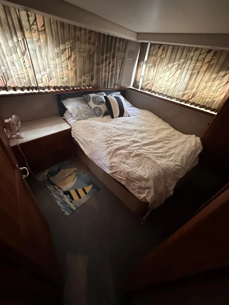 Slide: The Image of Interior of 1993 Carver 33 Aft Cabin with cozy bed and patterned curtains. - 19