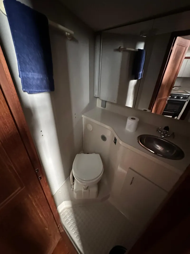 Slide: The Image of 1993 Carver 33 Aft Cabin bathroom with toilet, sink, and mirror. - 21