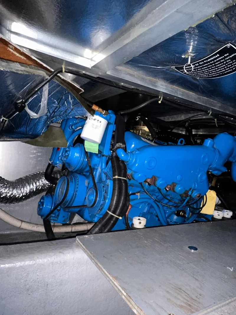 Slide: The Image of Engine compartment of a 1993 Carver 33 Aft Cabin boat, featuring a blue engine. - 24