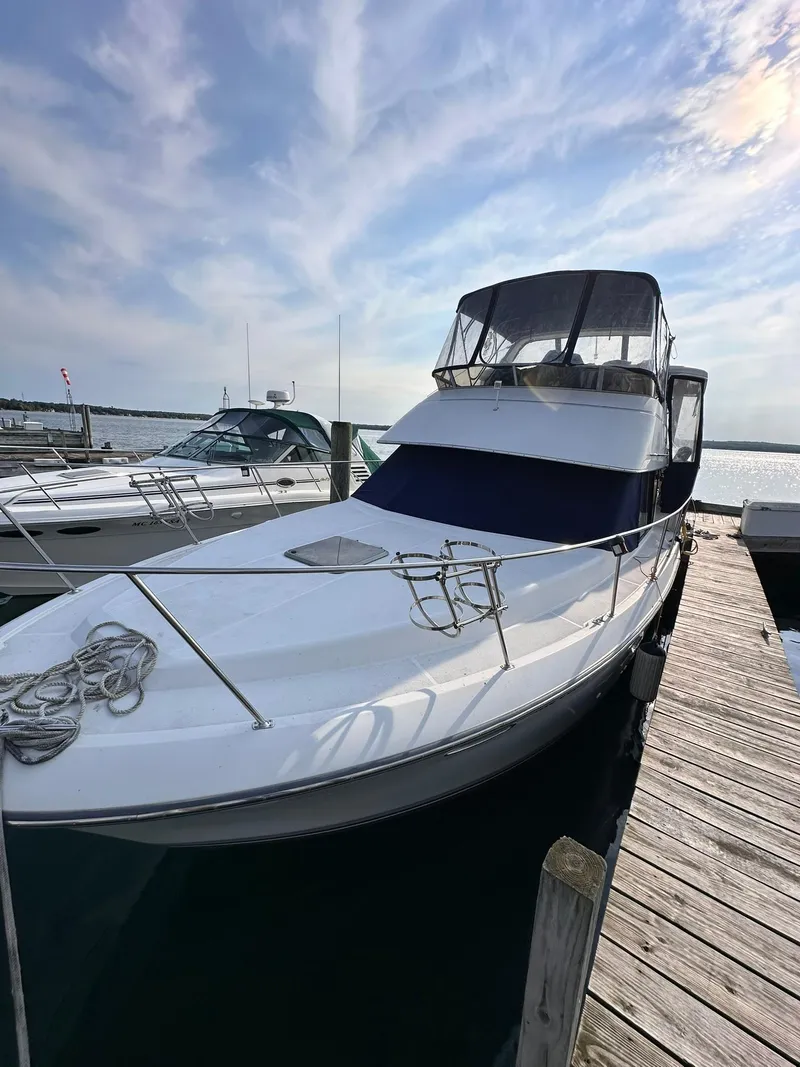 Slide: The Image of 1993 Carver 33 Aft Cabin boat docked at marina under a partly cloudy sky. - 3