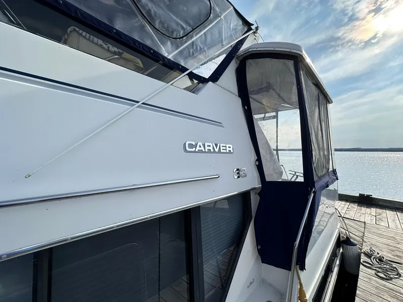 Slide: The Image of 1993 Carver 33 Aft Cabin yacht docked by the water under a clear sky. - 4