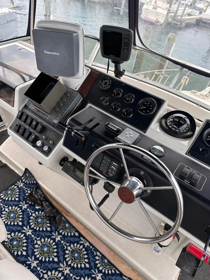 Slide: The Image of 1993 Carver 33 Aft Cabin helm with navigation equipment and patterned floor mat. - 6