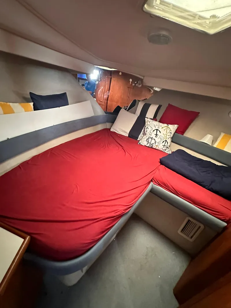 Slide: The Image of Interior of 1993 Carver 33 Aft Cabin with red bedding and decorative pillows. - 18
