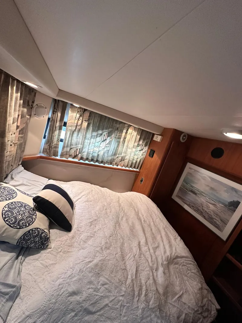 Slide: The Image of 1993 Carver 33 Aft Cabin bedroom with cozy bedding and decorative pillows. - 20
