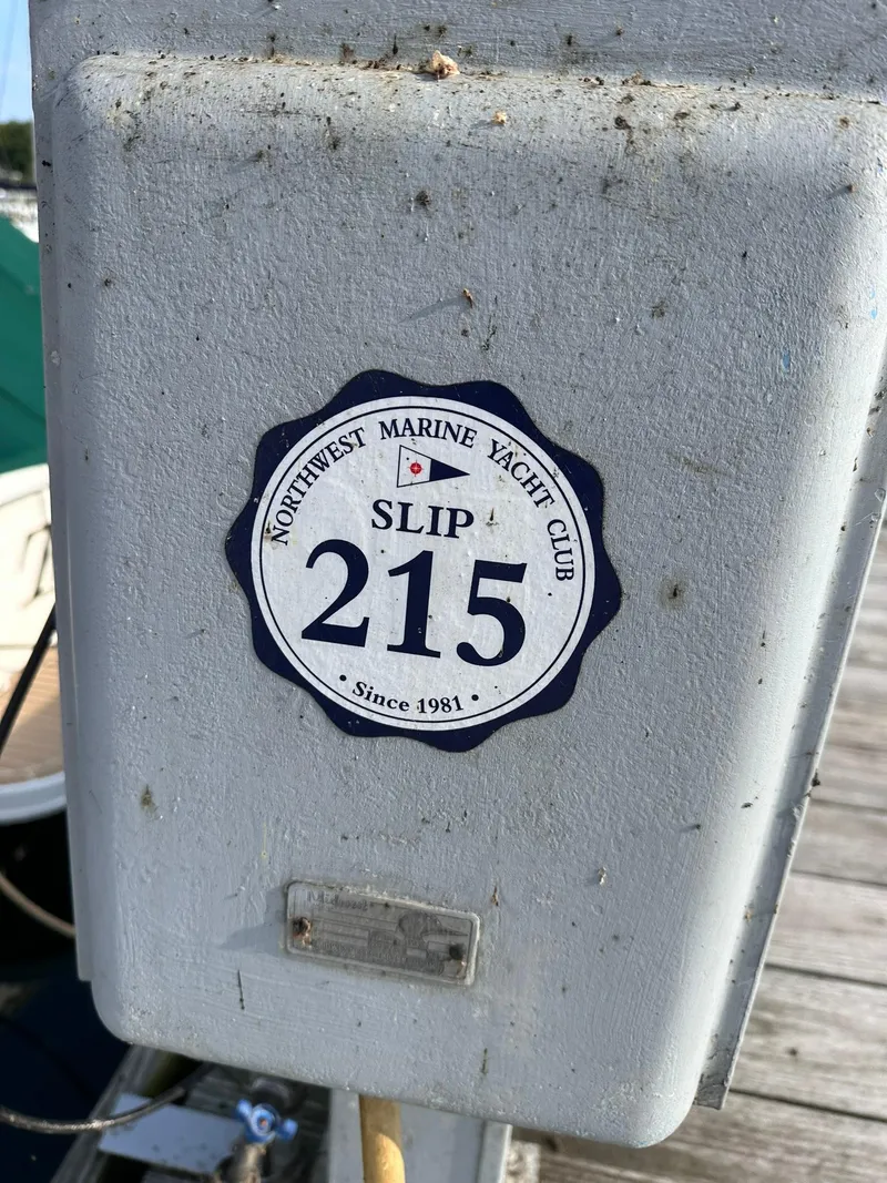 Slide: The Image of Sticker on dock post, "Northwest Marine Yacht Club, Slip 215, Since 1981." - 26