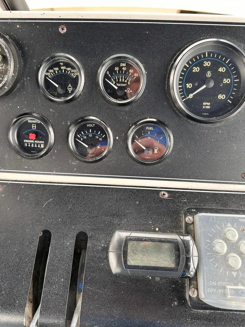 Slide: The Image of Dashboard of a 1993 Carver 33 Aft Cabin boat with various gauges and controls. - 8