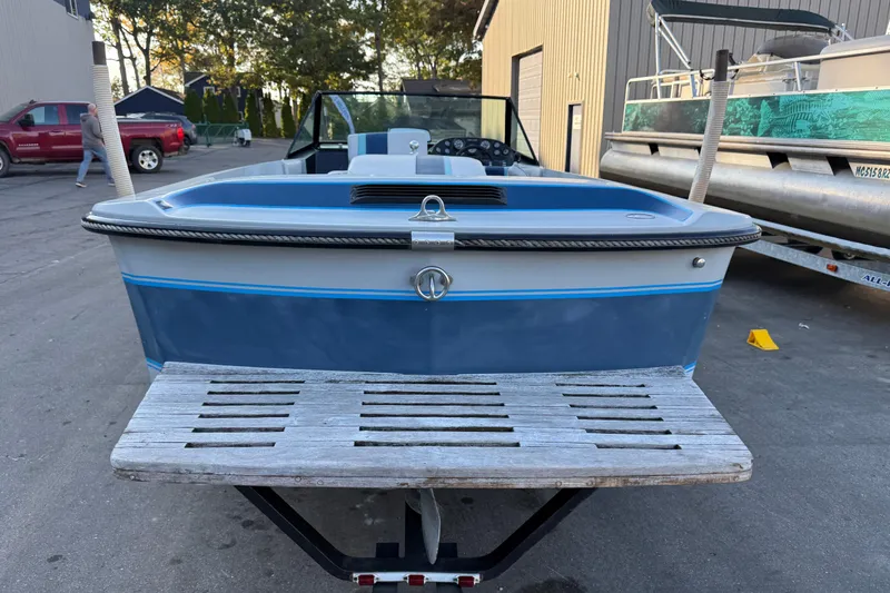 Slide: The Image of 1989 Correct Craft Ski Nautique boat on trailer, parked outdoors near buildings. - 12