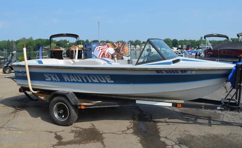 Slide: The Image of 1989 Correct Craft Ski Nautique boat on trailer, blue and white design, parked outdoors. - 2